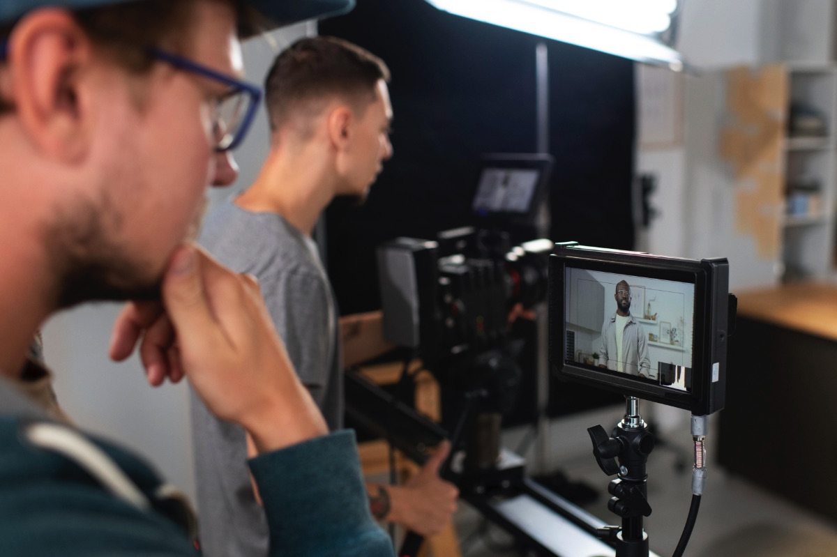 Video production company in action, filming with the use of a studio monitor and HD cinema grade camera.